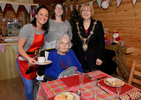 Coun Sybil Fielding enjoys an a private Christmas dinner at Ashley House Care Centre with her Mum Barbara Nash and Daughter Charlotte Fielding served by staff member Sarah Thorlby-coy in the care centres log cabin