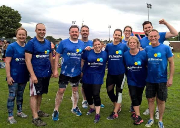 St Barnabas Hospice duo, Chris Wheway (fourth from left) and Caroline Swindin (third from right), taking part in an Its A Knockout event, based on the former TV show.