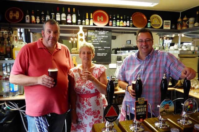 Tony Howkins, Lisa Howkins and David Stamp behind the bar.