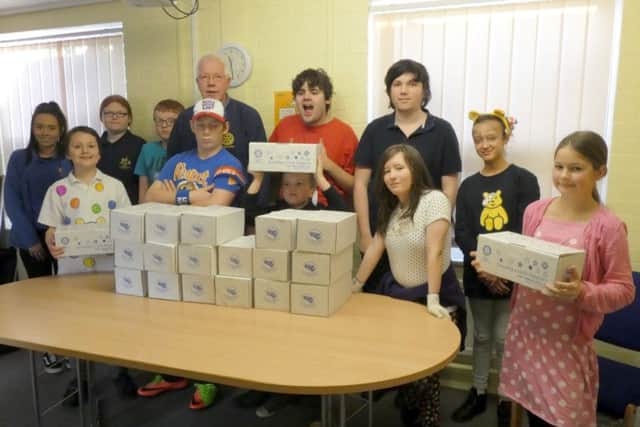 Students at St Lawrence School supported the Rotary Shoebox appeal with 20 filled boxes and bags of toys and gifts. Rotarian Peter Humphrey is pictured with some of the students when he went to collect the boxes. EMN-171128-113342001