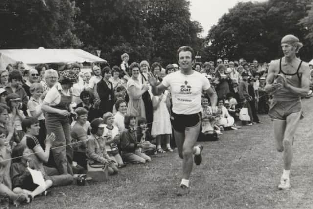 Alan Househam reaching the finish line of his epic 100-mile run applauded by friend John Holderness. EMN-170812-092637001