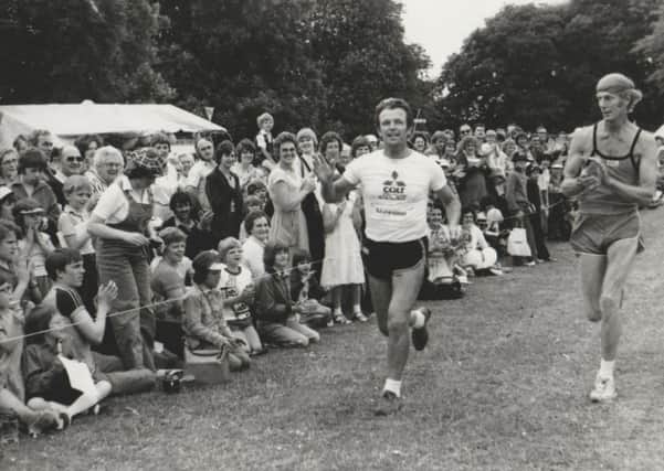 Alan Househam reaching the finish line of his epic 100-mile run applauded by friend John Holderness. EMN-170812-092637001