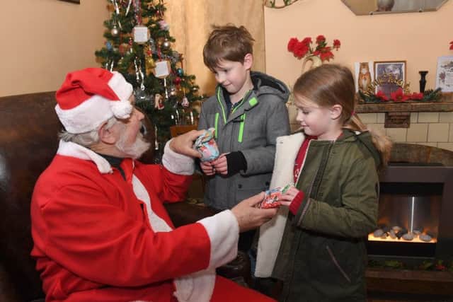 Edwardian Christmas at Heckington Mill. Mason Lambert 8 and Bella Lambert 5 of Great Hale with Father Christmas. EMN-171112-095623001