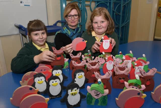 Evie Nixon, Alison Aranda and Daisy Pexton with wooden decorations made by pupils. PHOTO: David Dawson. EMN-170312-211304001