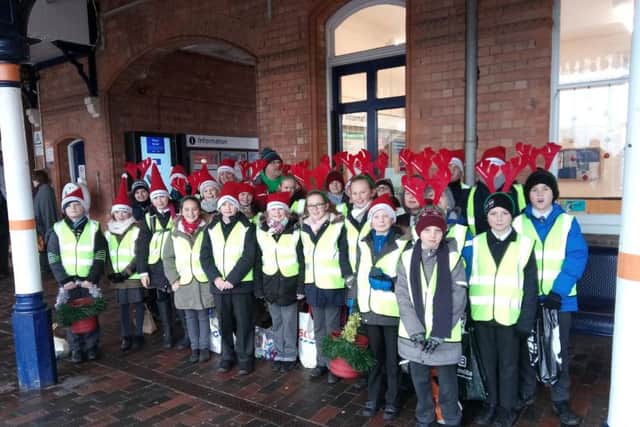 Our Lady of Good Counsel RC School pupils perform Christmas carols on Sleaford station with Community Rail Partnership Officer Kaye Robinson and Sustrans Schools Officer Jon Moody.