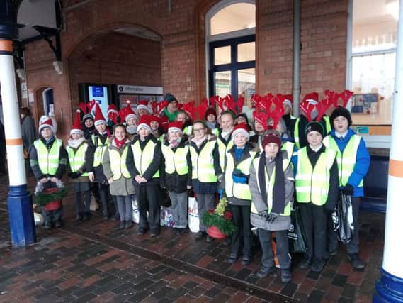 Our Lady of Good Counsel RC School pupils perform Christmas carols on Sleaford station with Community Rail Partnership Officer Kaye Robinson and Sustrans Schools Officer Jon Moody.