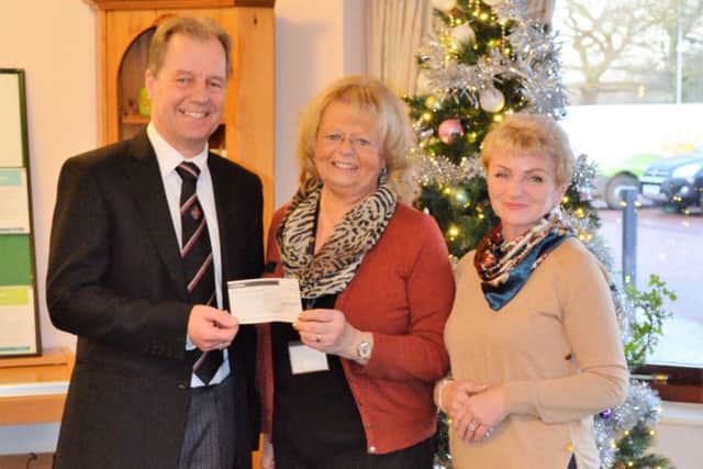 Alastair Huteson (left) and hsi wife Diane (right) are pictured presenting the cheque to Hospice Fundraiser Anne Millettat Lindsey Lodge Hospice EMN-171219-131238001