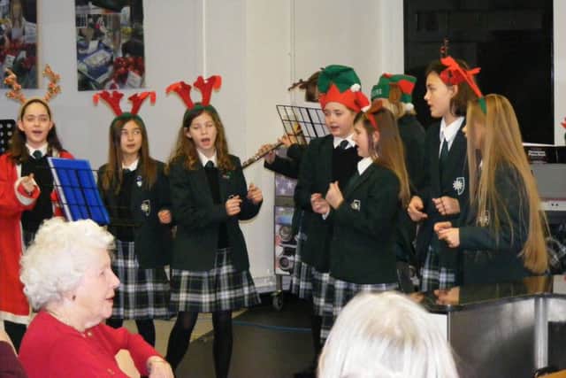 Year 7 students perform Christmas songs for older residents during the lunch at Kesteven and Sleaford High School. EMN-171220-164010001