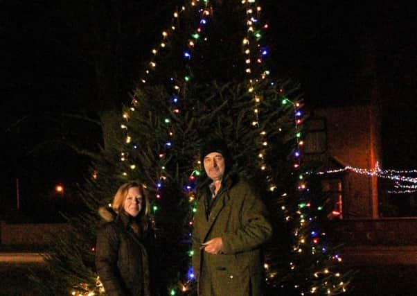 Sarah Line and John Cross standing in front of the tree on Helpringham village green. EMN-171221-152129001