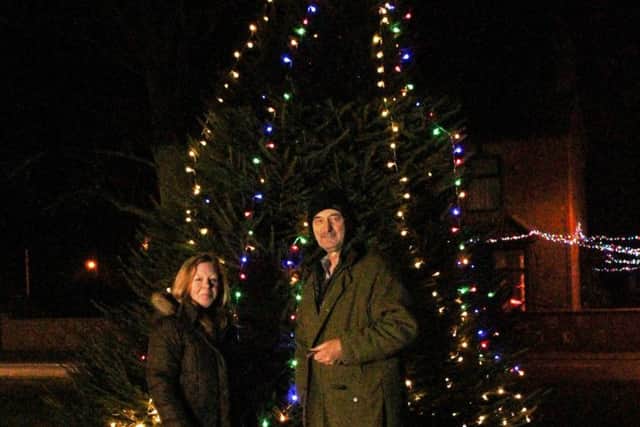 Sarah Line and John Cross standing in front of the tree on Helpringham village green. EMN-171221-152129001