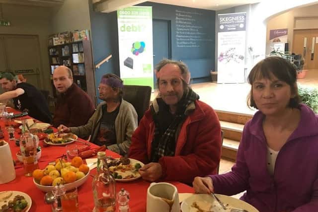 Volunteer Korallou Antoniou (right) sits down to a festive meal at the Storehouse with some of the town's homeless residents. ANL-171227-152752001
