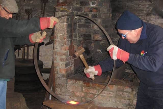 Hammering a cart wheel at Welbourn Forge. EMN-171229-145948001