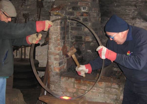Hammering a cart wheel at Welbourn Forge. EMN-171229-145948001