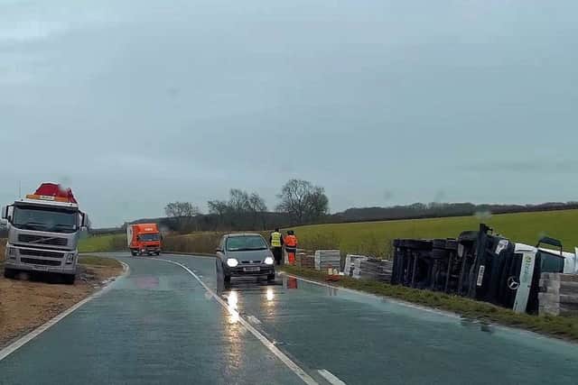 Recovery workers begin to block the A52 while removing the overturned lorry from the roadside. Photo: Ted Clark EMN-180301-114716001