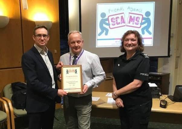 NKDC's Phil Roberts receives his 'friends' certificate from deputy PCC Stuart Tweedale and Sgt Caroline Broughton. EMN-180115-120109001