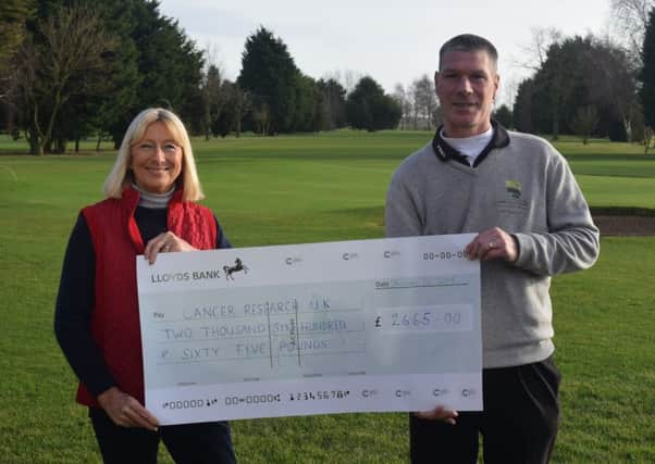 Previous captains Stuart Thomas and Gloria Bursnell are pictured with their cheque for Cancer Research UK.