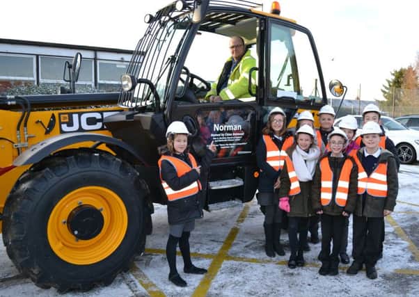 Chloe Betmead, of Bardney church of England and Methodist School, meets the telehandler Norman she named as part of Chestnut Homes competition. EMN-180122-161012001