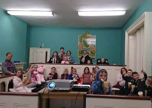 Youngsters settling down for the film night in the court room at the Old Police Sattion