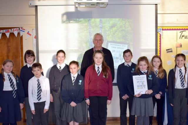 Chairman of the Tree Group, Adrian Wilson, with the pupils who had their posters included in the calendar. EMN-180123-130016001