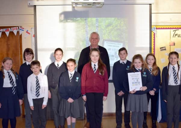 Chairman of the Tree Group, Adrian Wilson, with the pupils who had their posters included in the calendar. EMN-180123-130016001