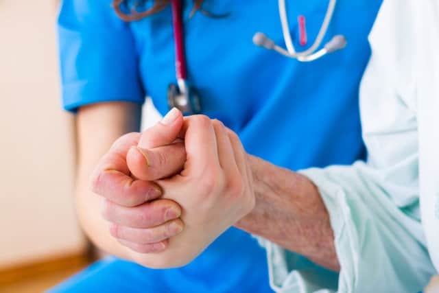 Nurse holding patient's hand (stock image)