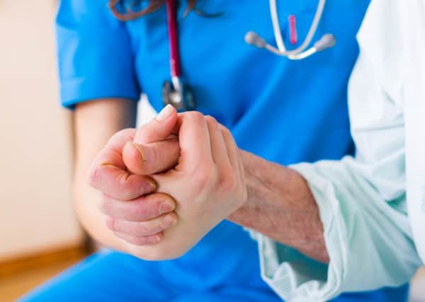 Nurse holding patient's hand (stock image)
