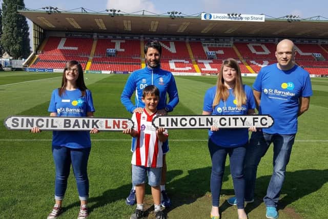 Represenatives from St Barnabas Hospice with a young Lincoln City fan and club manager Danny Cowley (centre). EMN-180126-122157001