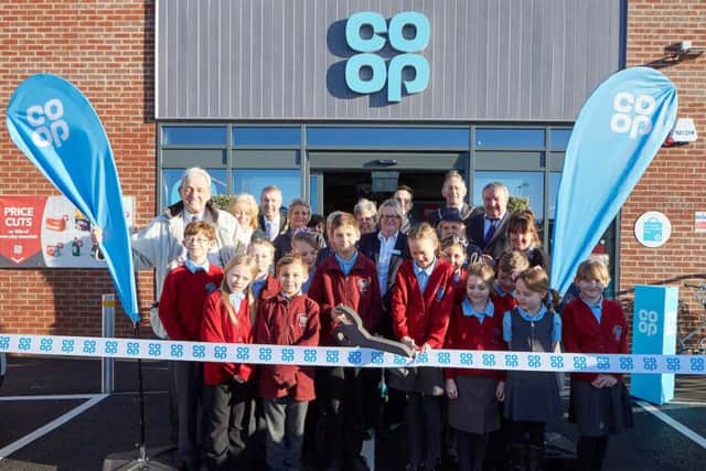 James Latham (aged 10) and Lucy Major (aged 10) cut the ribbon, with their classmates from the Sutton on Sea Primary School, together with local councillors and Jayne Snowden (Store Manager). Photo: Les Gibbon.