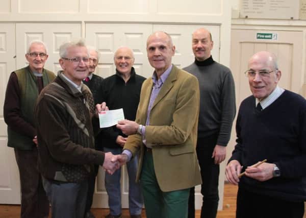 Joe Gibson, choir treasurer is pictured, left, handing the cheque to charity secretary Vic Rice (centre), with Musical Director Ray Wylie (right) and some of the other choir members behind. EMN-180602-133805001