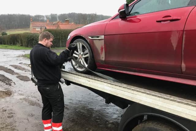 A recovery man loading the damaged Jaguar onto a truck. EMN-180502-160022001
