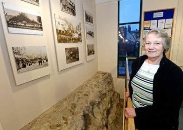 Sheila Jonkers in front of a section of the Roman wall in the town library