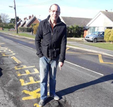 Paul Wilson stood by the pothole in Chapel St Leonards that broke a suspension spring of his car. ANL-180213-101746001