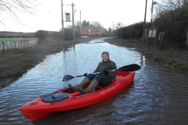 Olivia Apletree in her father's kayak illustrating how bad the flooding is along the road from Aswardby to Harrington. ANL-181202-133850001