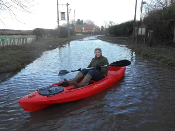 Olivia Apletree in her father's kayak illustrating how bad the flooding is along the road from Aswardby to Harrington. ANL-181202-133850001