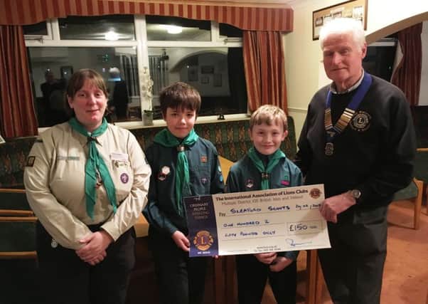 Lion President Paul Whitworth presents the cheque to Scout Leader Helen Zealand, and scouts Oliver Tucker and Callum Logan from Sleaford Scout Group.
