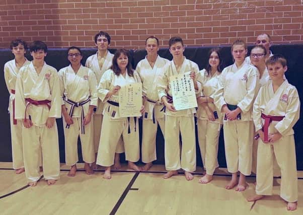 Newly-promoted black belts Kathleen and Callum with their clubmates EMN-180203-130308002