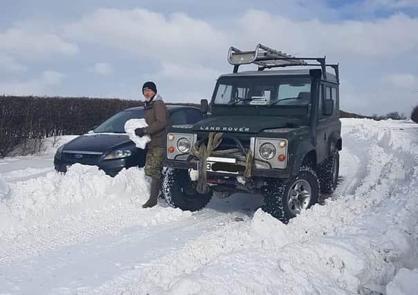 Keith Mallinson clearing the way for another car to escape the snowdrifts EMN-180503-154227001