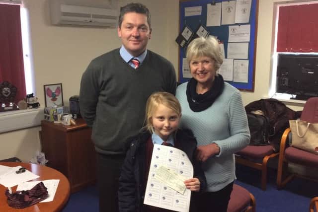 Lioness Suzanne Creedon presents £40 to William Alvey School for them to purchase new books.