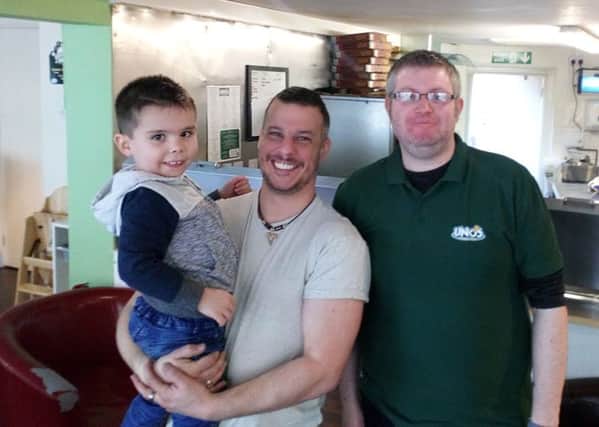 The happiest man alive: Paul Edwards (centre) with son Elliott (5) and  owner Graeme Midgley at Unos Pizzeria and Bistro in Horncastle.