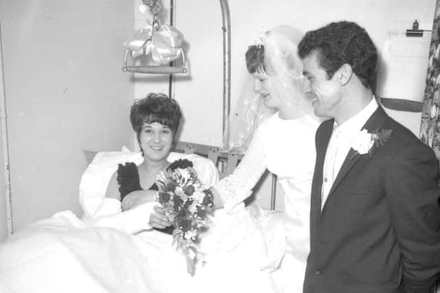 Bridesmaid-to-be Peggy Bray, of Friskney, ended up in London Road Hospital, Boston, rather than church after suffering a broken arm in a car accident in 1968. Here, she receives the bouquet from bride Pamela Wray by way of consulation. EMN-180314-163732001