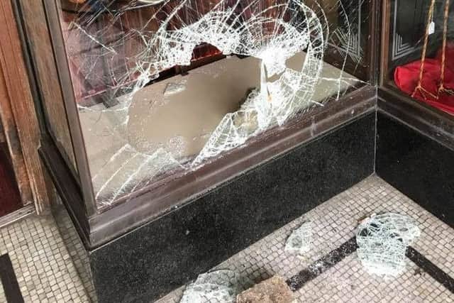 The smashed window of Spalls of Skegness showing an empty shelf. ANL-180316-081352001
