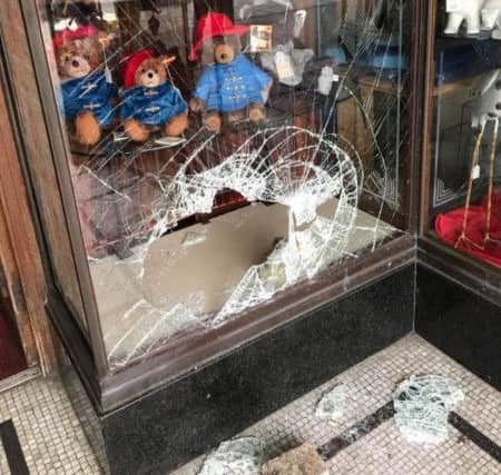 The smashed window of Spalls of Skegness showing an empty shelf. ANL-180316-081352001