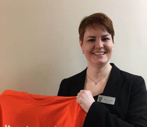 Headteacher Helen Wines holding a T-shirt for Muscular Dystrophy UK. EMN-180314-131821001