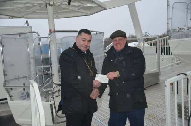 Jan de Koning, of r The Giant Wheel Co, presenting a cheque to Skegness Mayor Coun Danny Brookes for Â£200 for his charities. Photo: Barry Robinson. ANL-180320-110015001