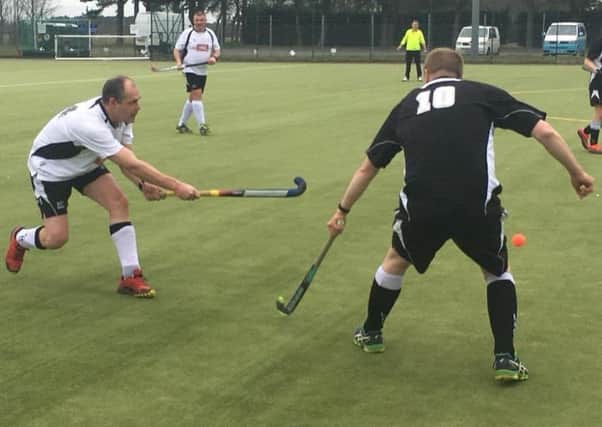 Third team captain Andy Cade (white) competes to clear his lines under pressure from Leadenhams leading scorer James Ireland EMN-180326-143317002