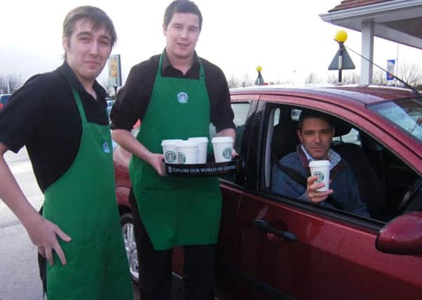 Cheers... pictured (from left) trainee supervisor Luke Ayre and manager Craig Wilkinson, of Starbucks, with stranded motorist Mark Vazro, of Pinchbeck.