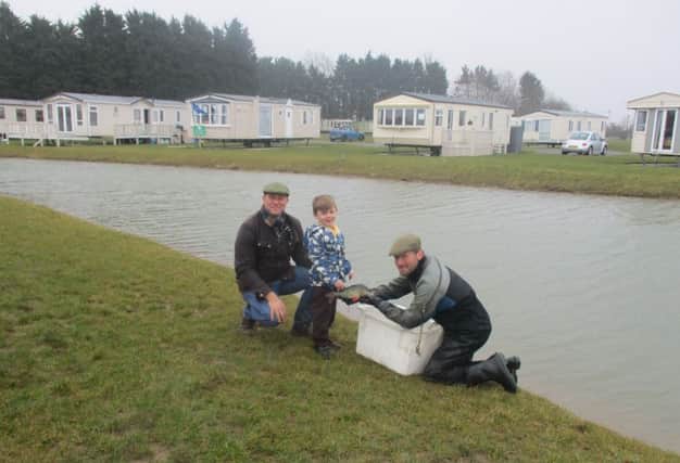 Gareth Pinder, Teddy Pinder and aquatic consultant Ruben Page at Belvedere Lakes Holiday Home site at Croft place 'Big Bad Barry' in their lake. ANL-180328-170616001