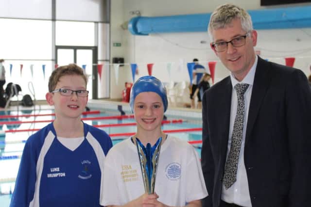 St Michael's swimmers Luke Brumpton and Gemma Damms are presented with the senior trophy by Magna Vitae managing director Mark Humphreys EMN-180330-110432002