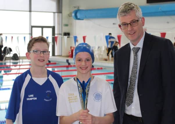 St Michael's swimmers Luke Brumpton and Gemma Damms are presented with the senior trophy by Magna Vitae managing director Mark Humphreys EMN-180330-110432002