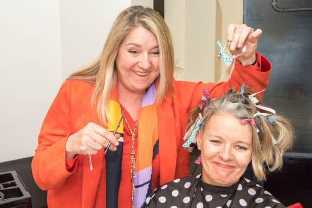 Friend, and cancer sufferer, Sue Thompson gets to work with the scissors. Picture: John Aron.